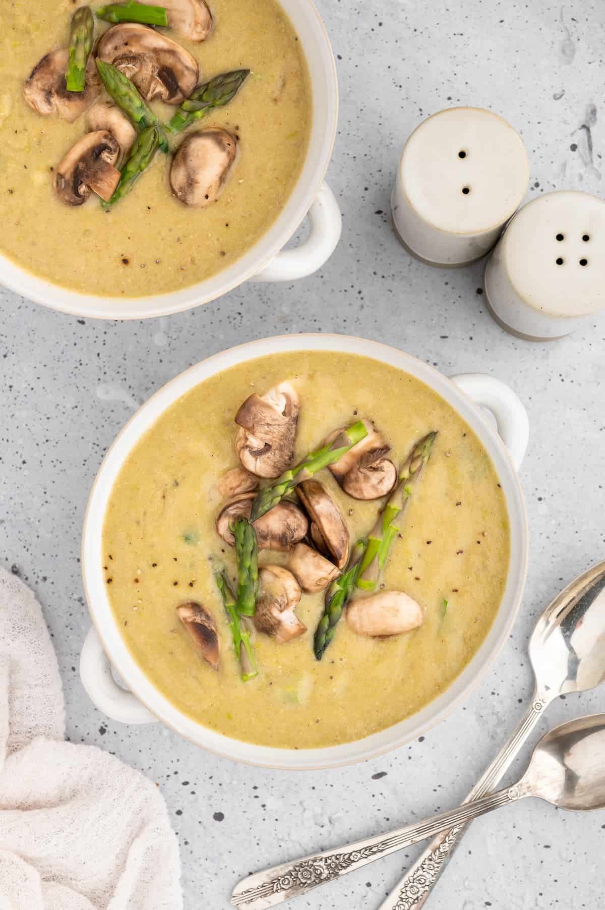 Two bowls of vegan asparagus soup.