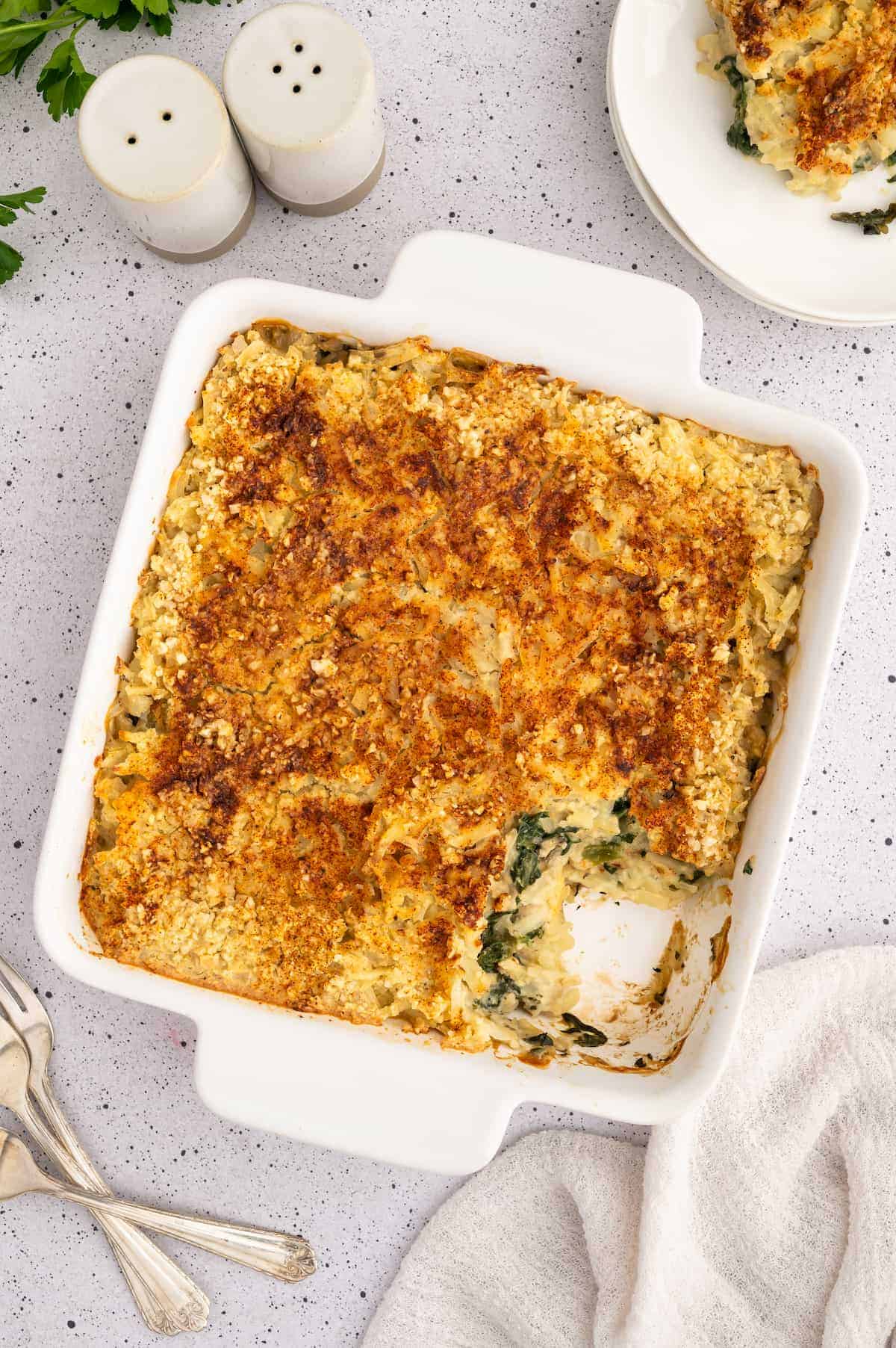 A top-down shot of a vegan casserole, with one piece cut out.