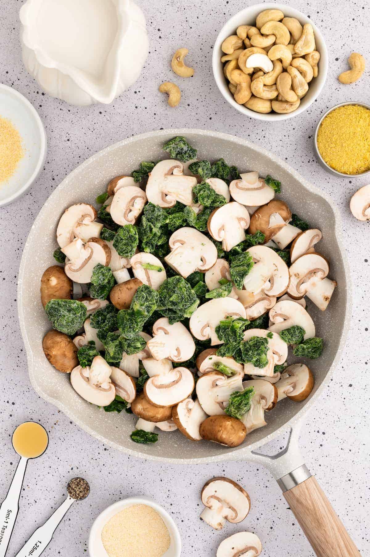 Mushrooms and spinach in a sauté pan.