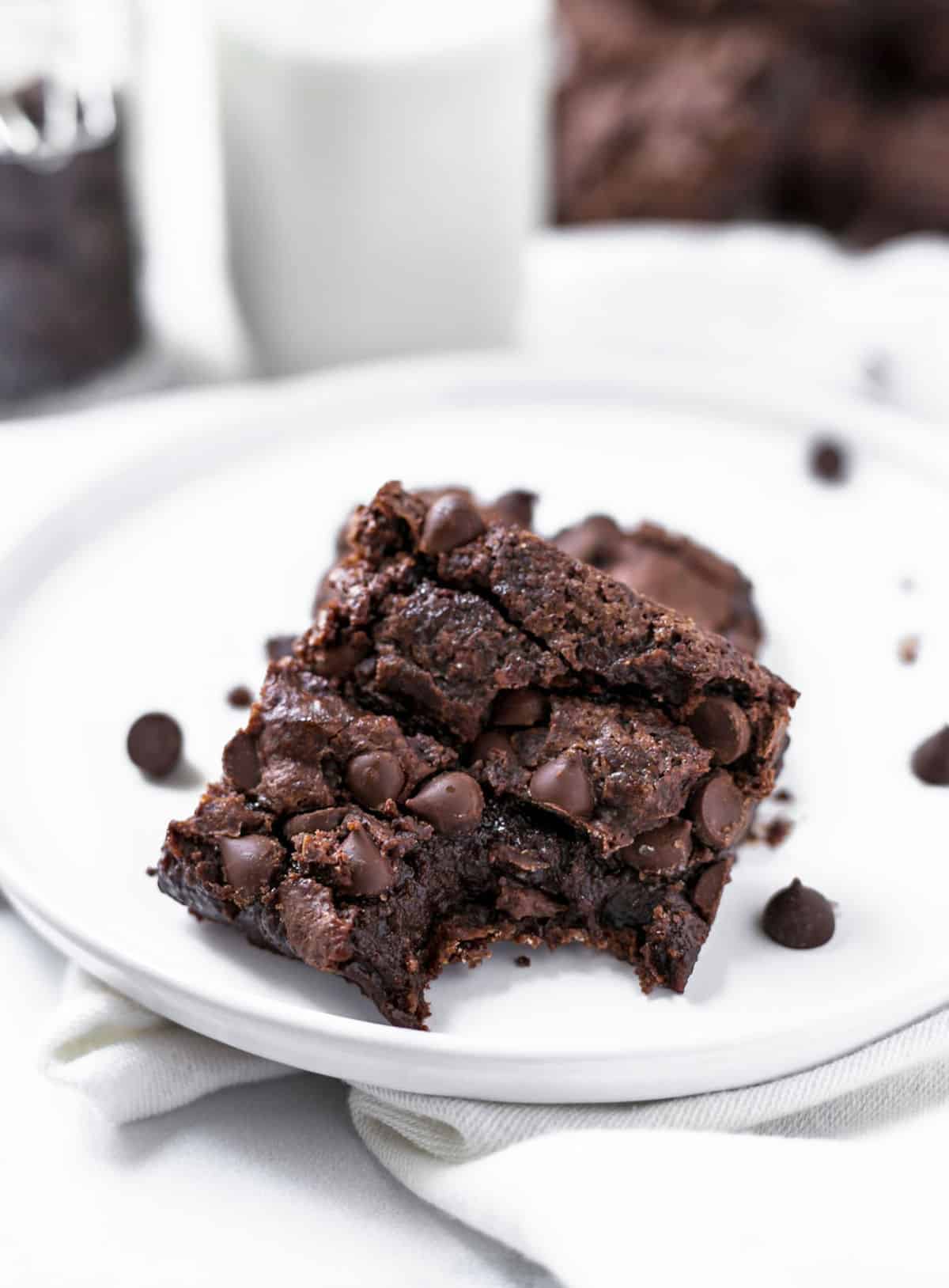 Vegan brownie on a plate with a bite missing.