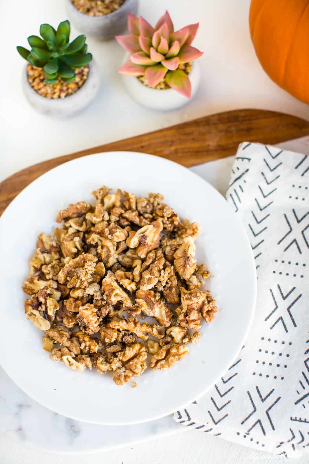 White bowl filled with nuts, a candied walnuts recipe. 