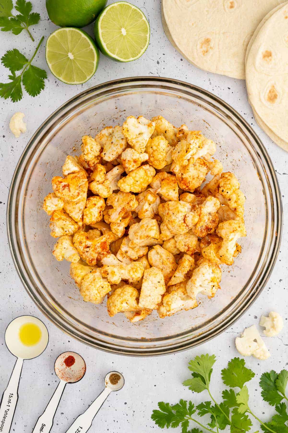 A bowl of seasoned cauliflower florets.