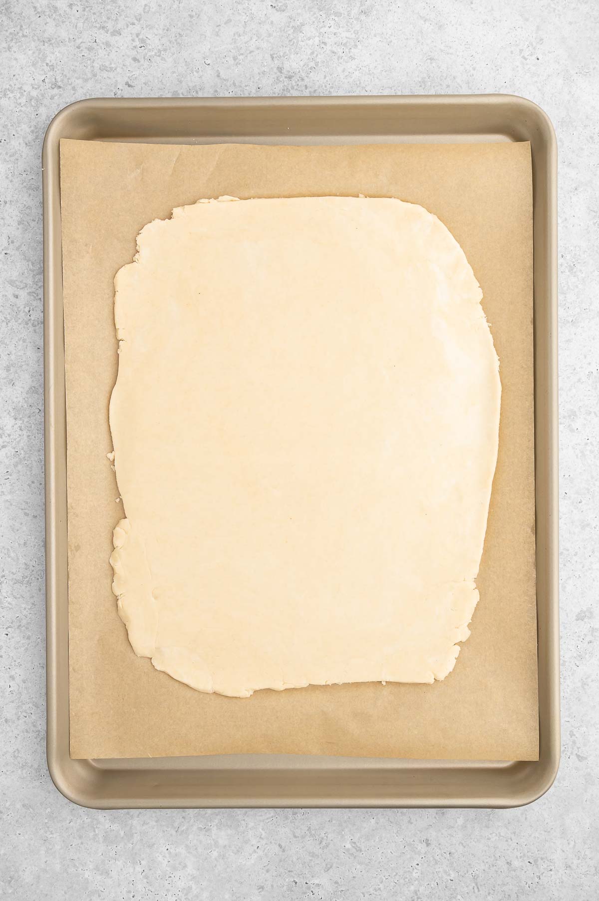 The rolled out pot pie crust on a baking sheet lined with parchment paper.