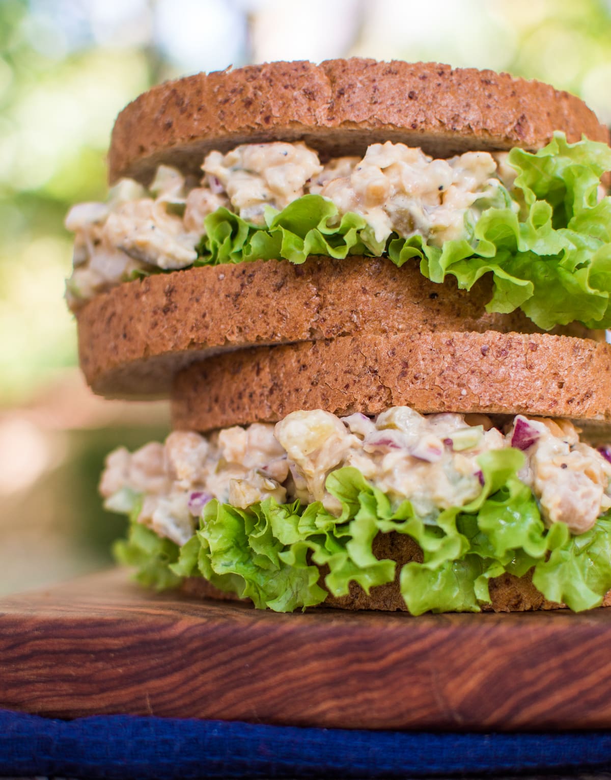 Two vegan chicken salad sandwiches stacked on one another.