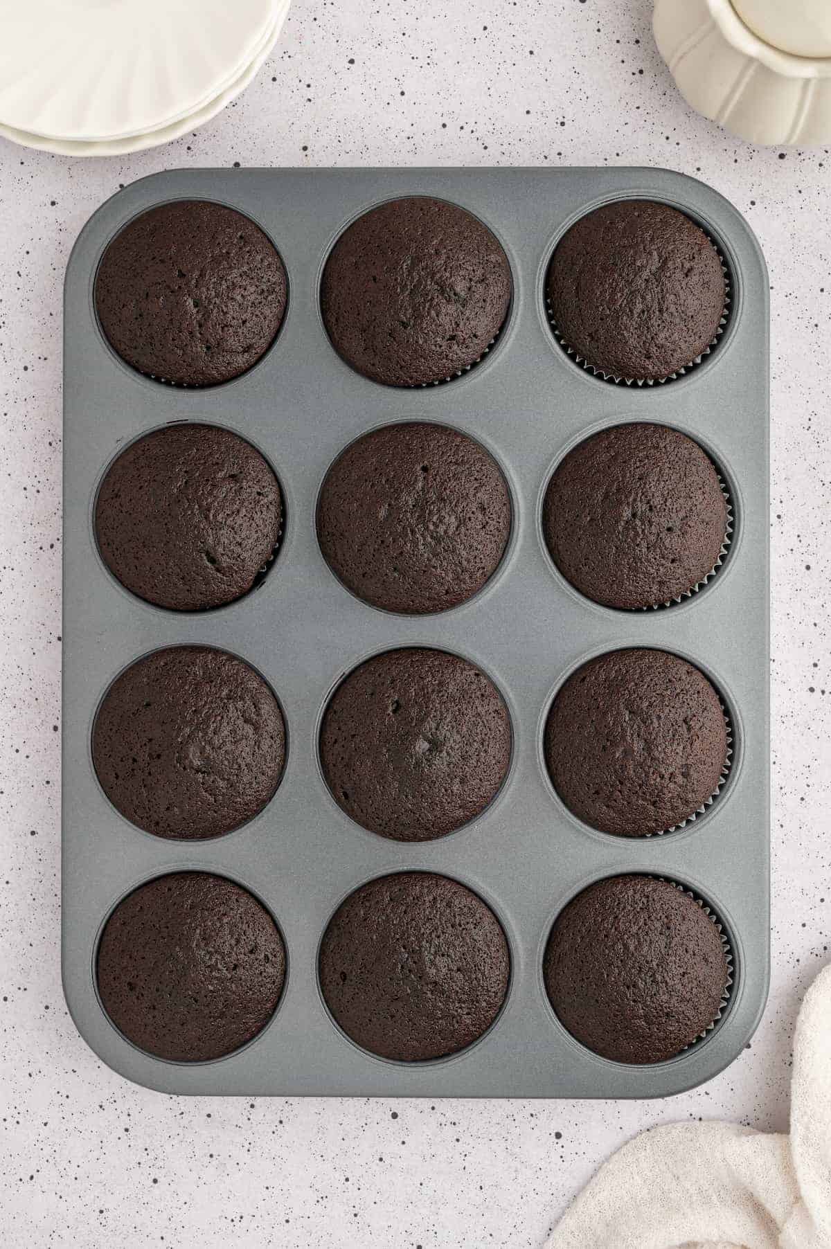 Vegan chocolate cupcakes in pan after baking.