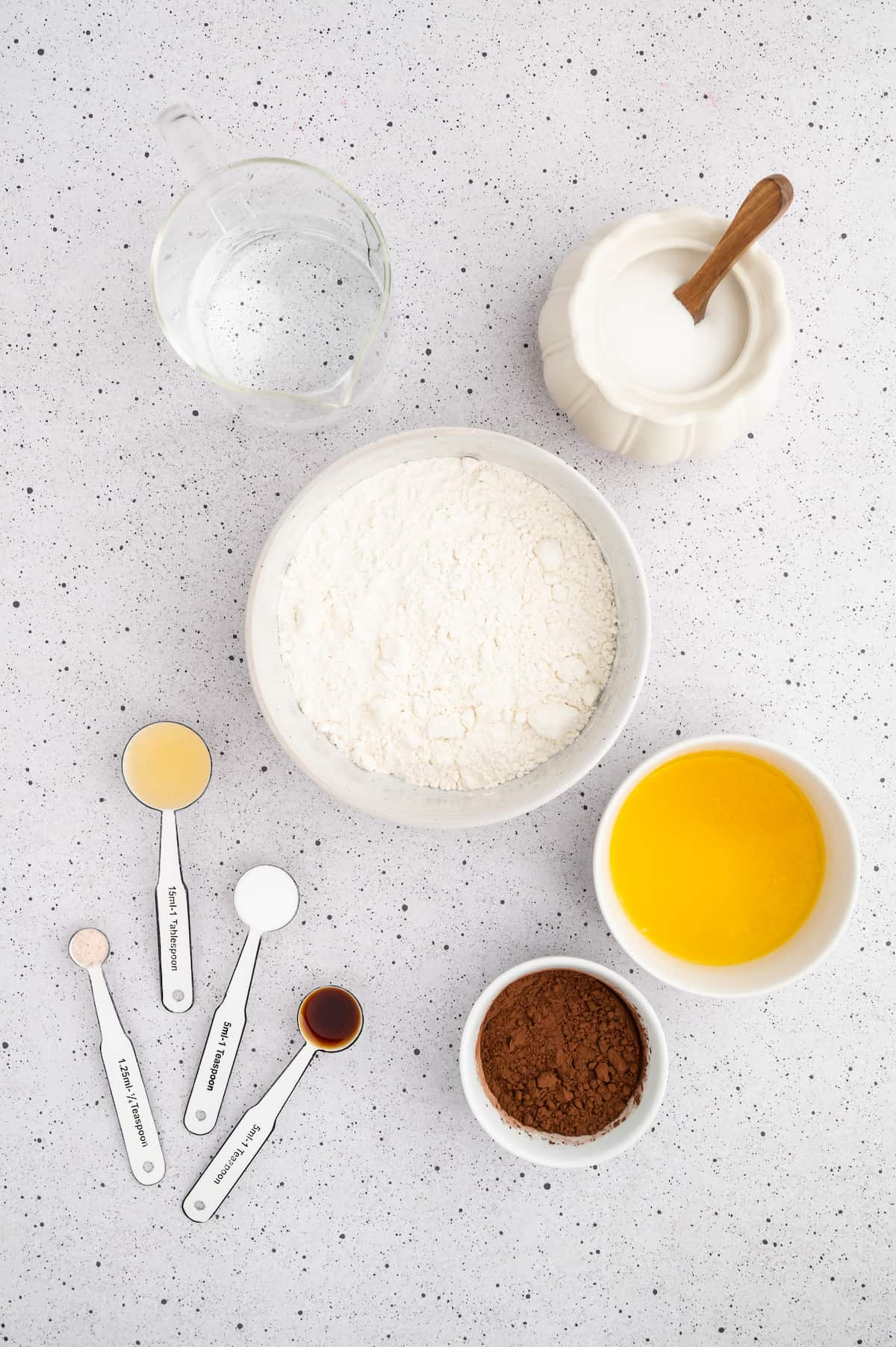 Vegan ingredients for vegan cupcakes measured in bowls and spoons.