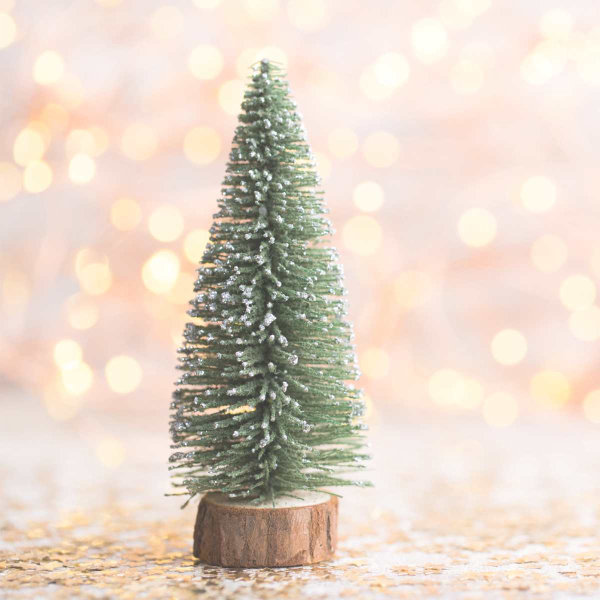 Christmas tree decoration with Christmas lights behind it.