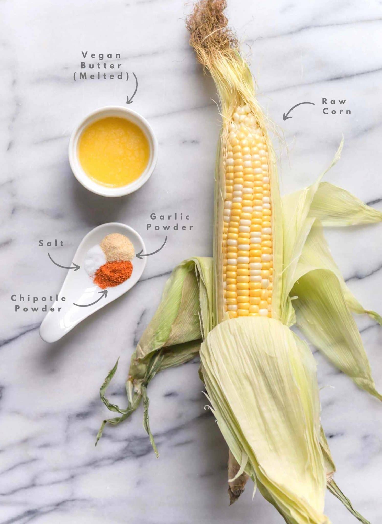 Vegan Corn Ribs Ingredients Flatlay With Cob of Corn Vegan Butter Chipotle Salt and Garlic Powder
