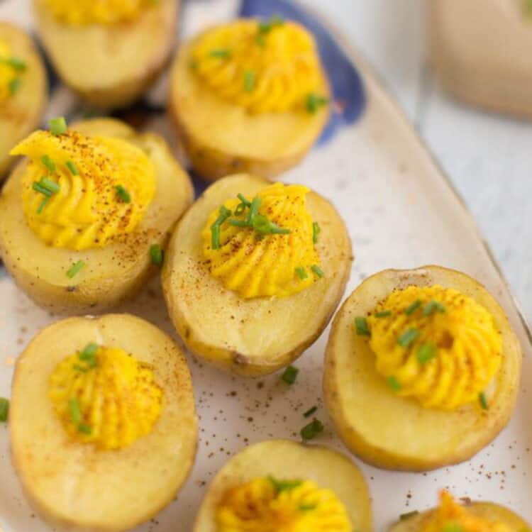 Vegan deviled eggs on a plate topped with chives.