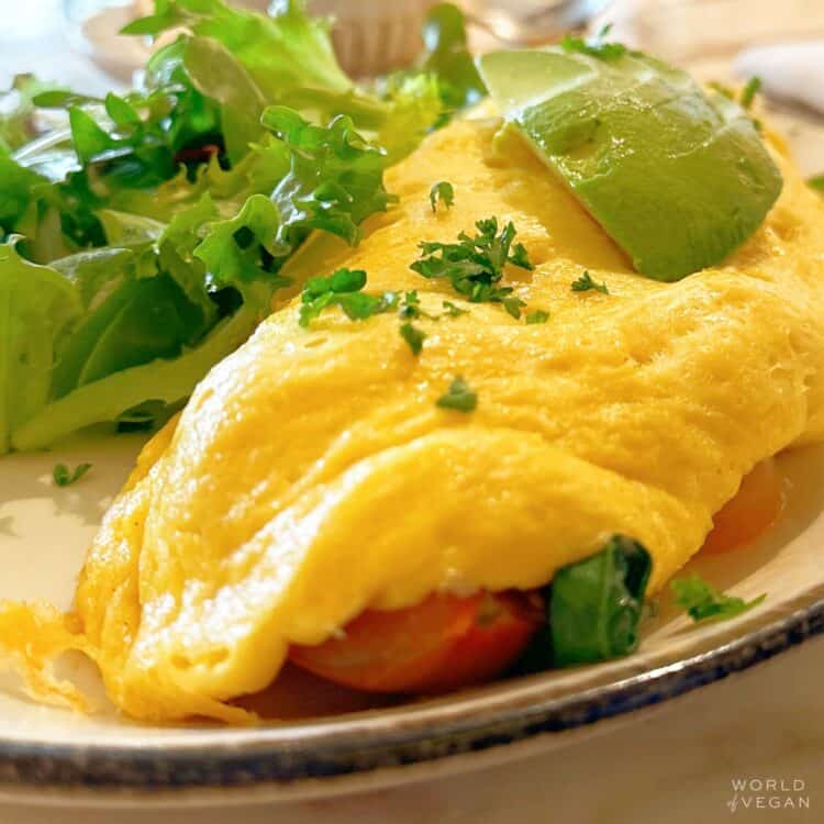 Vegan egg omelet topped with avocado and herbs.