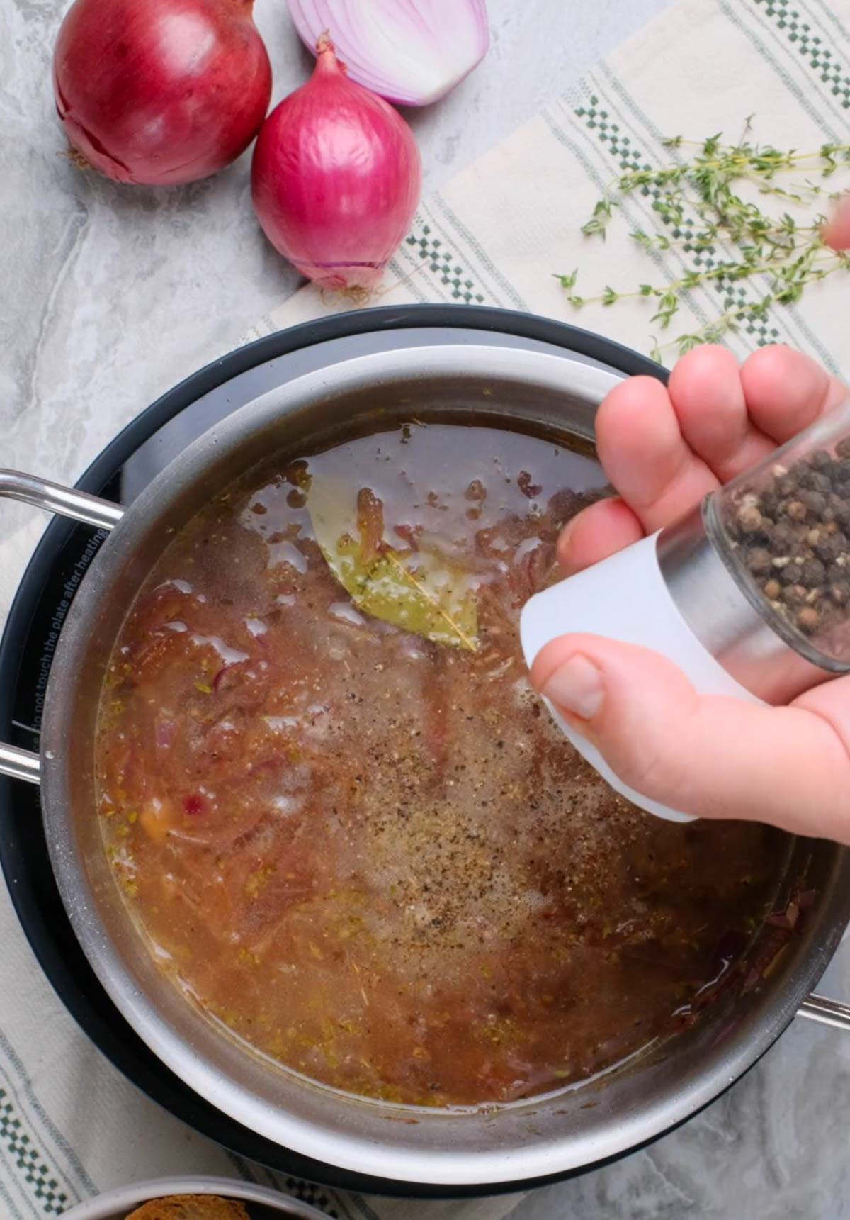 Vegan French Onion Soup being seasoned.