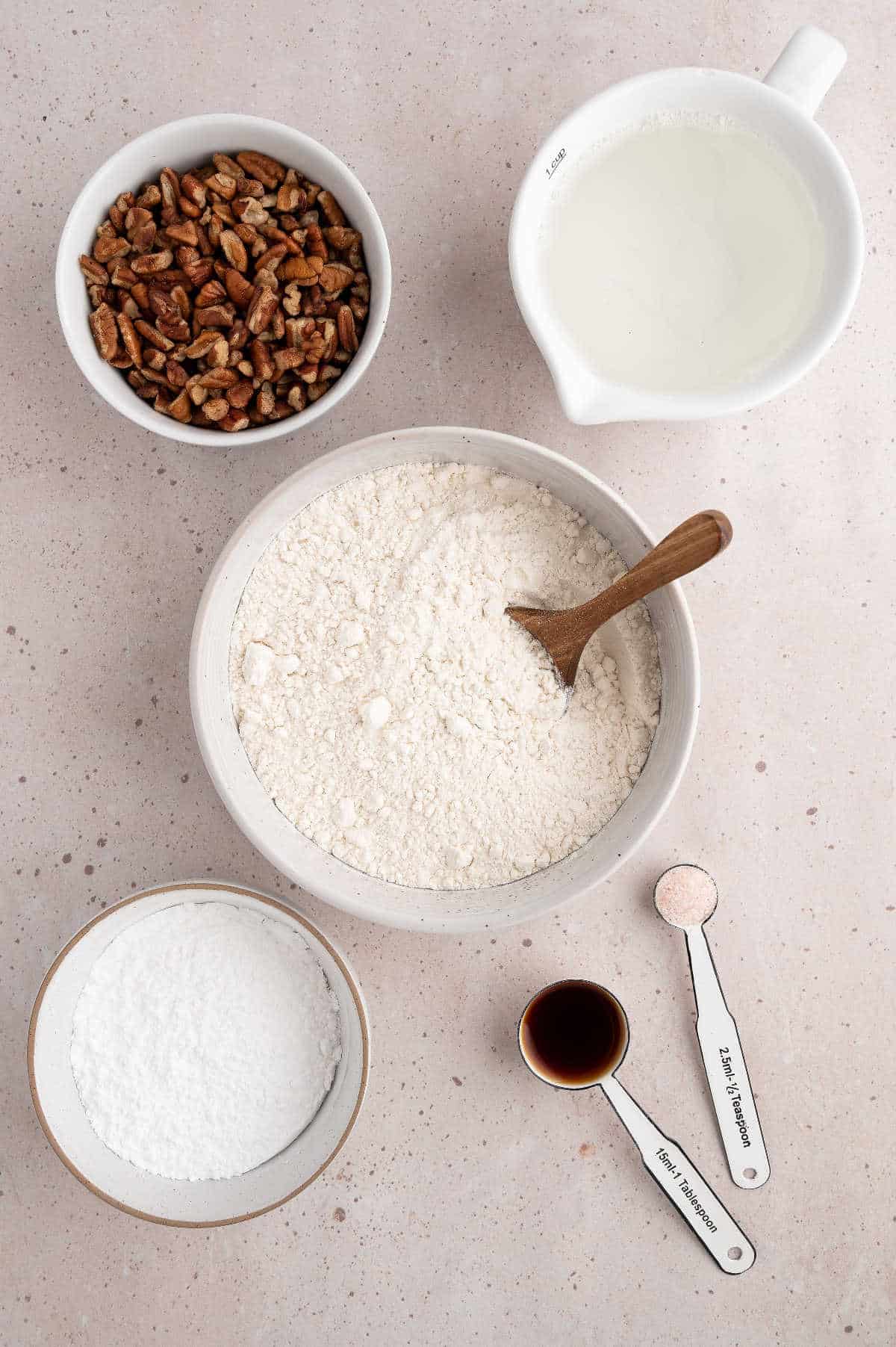 Ingredients for Mexican wedding cookies measured in bowls.