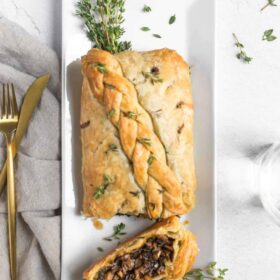 vegan mushroom wellington roast with braided puff pasty on a thanksgiving dinner table