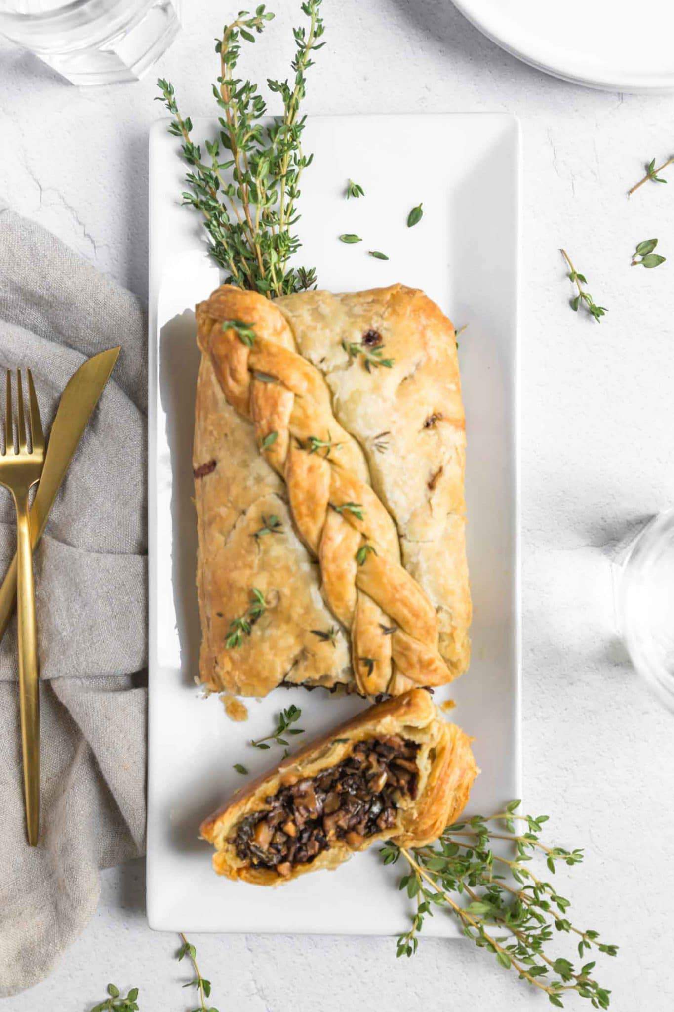 vegan mushroom wellington roast with braided puff pasty on a thanksgiving dinner table