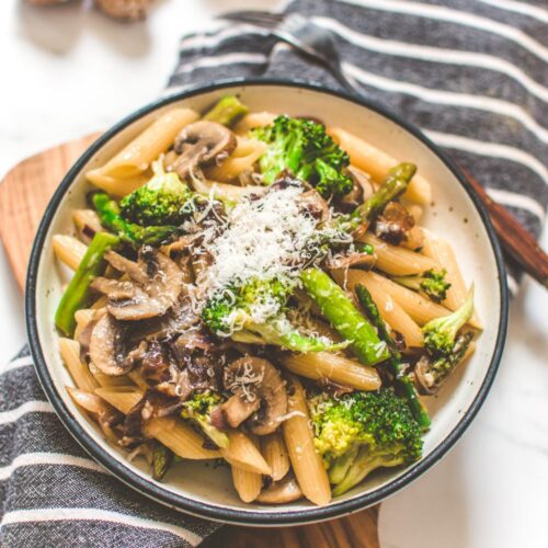 Pasta Dish Served with Vegetables on a Bowl topped with Grated Vegan Cheese