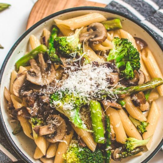 Pasta Dish Served with Vegetables on a Bowl topped with Grated Vegan Cheese