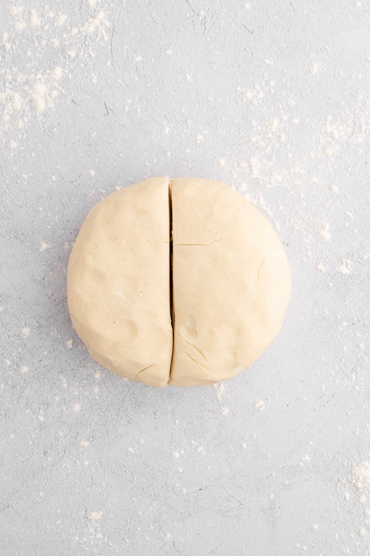 The rolled vegan pie crust dough sliced in half.