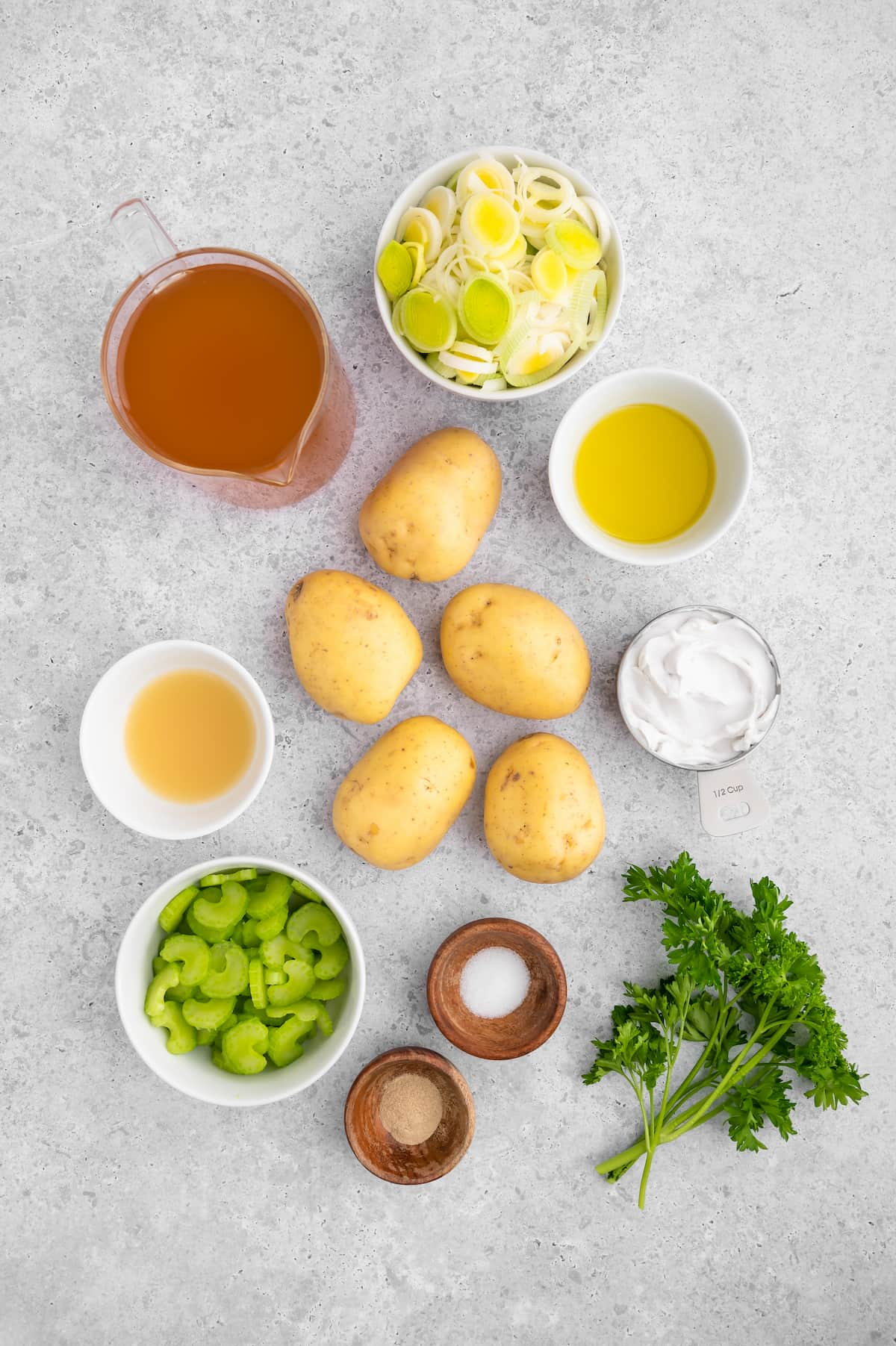 Gathered ingredients for vegan potato leek soup in various bowl and containers.