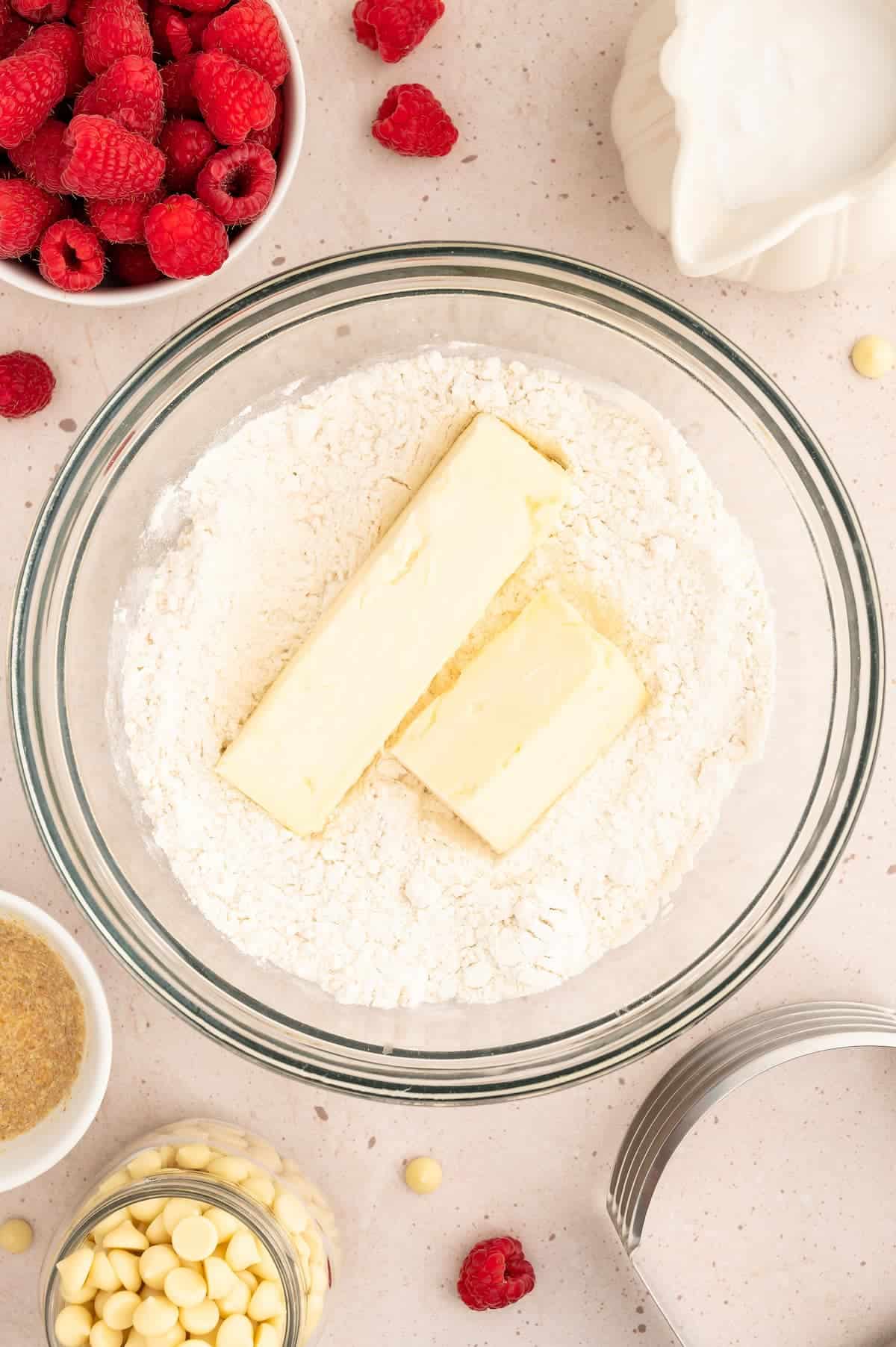 Vegan butter on top of flour in a prep bowl.