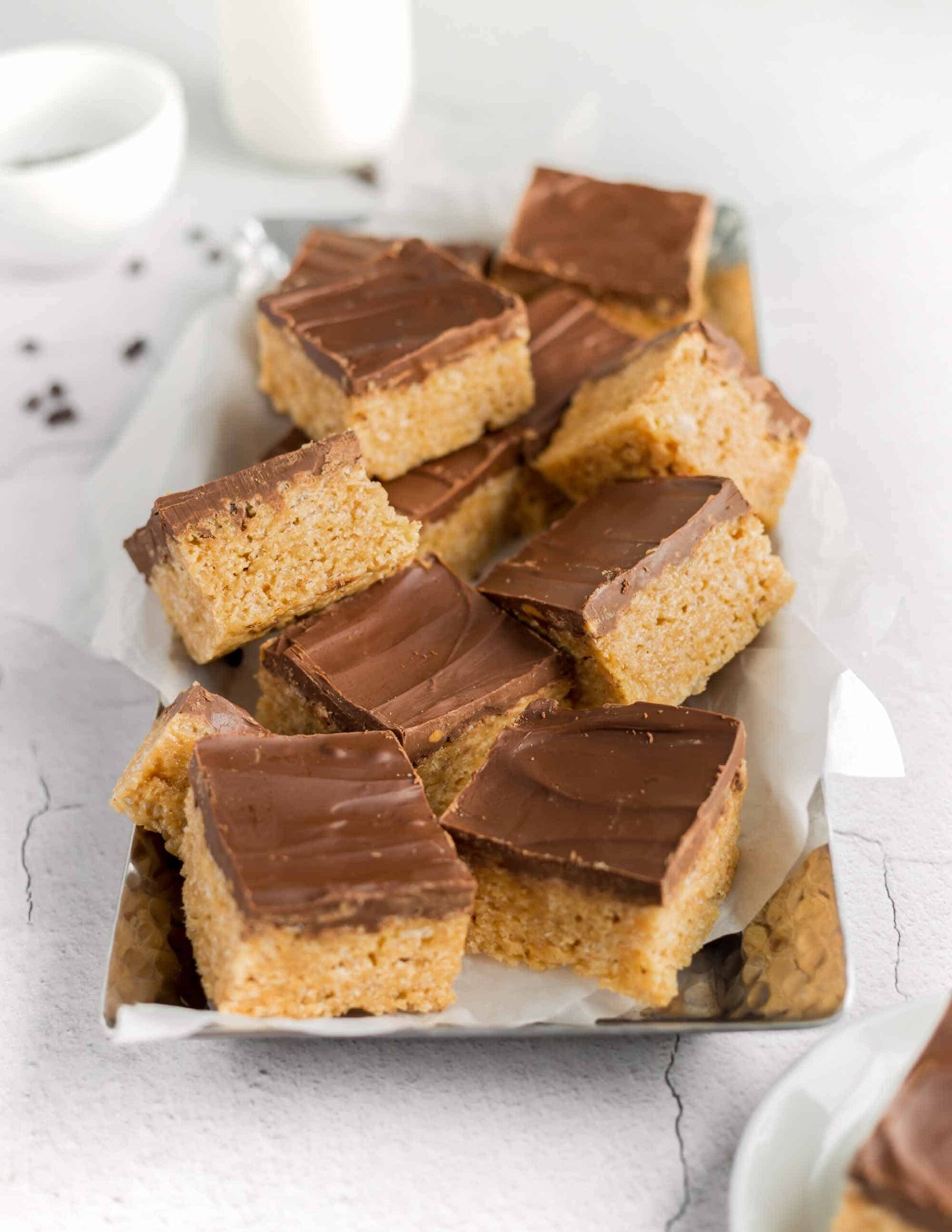 Vegan Scotcharoos Chewy Caramel Rice Krispies With Chocolate Coating Served on a White Plate