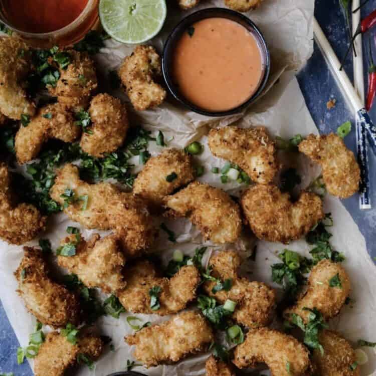 Vegan shrimp on a board garnished and served with dipping sauces.