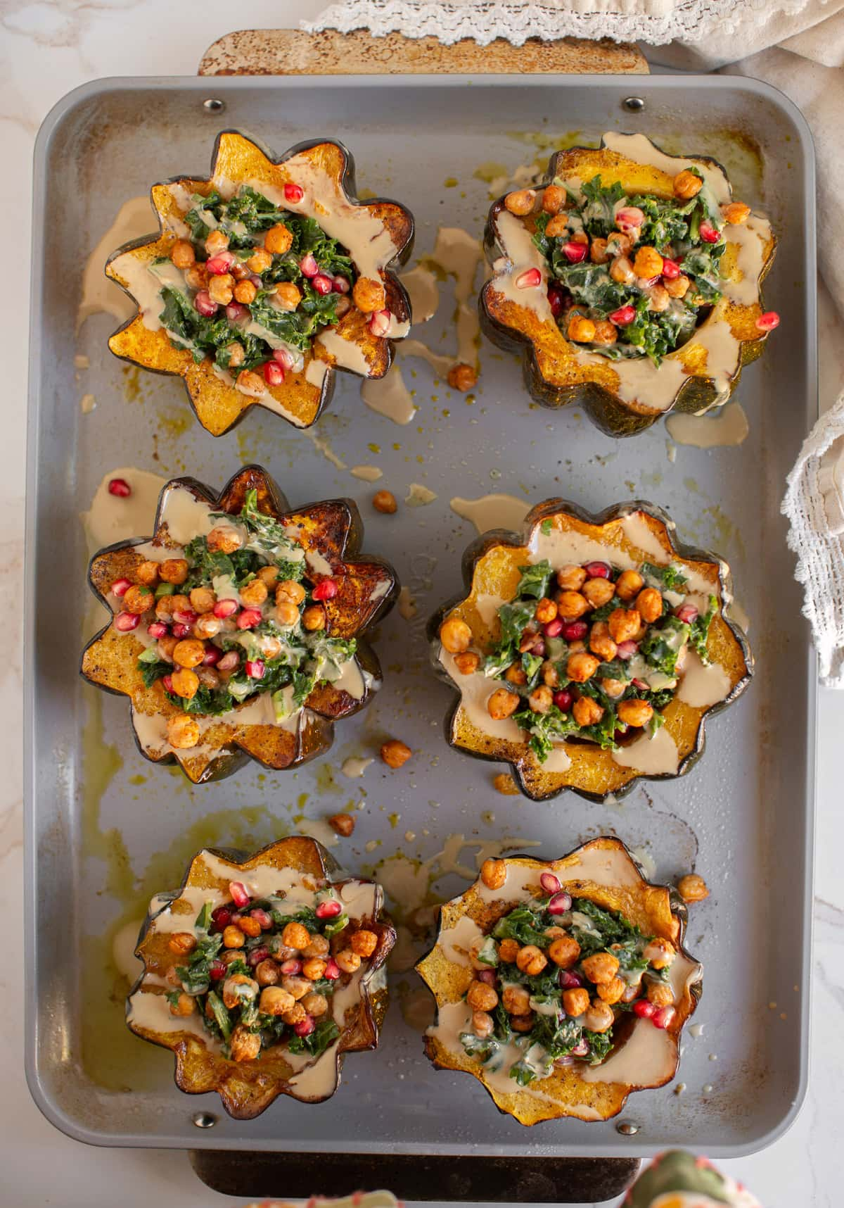 Vegetarian stuffed acorn squash on a baking sheet.