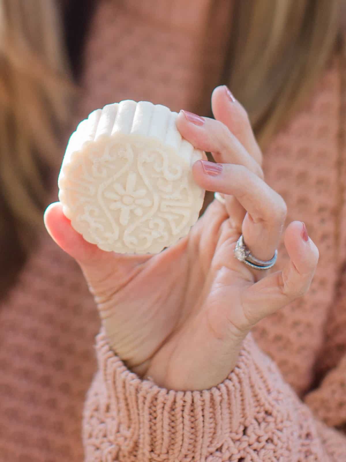 Up-close photo of a solid shampoo bar unwrapped. 