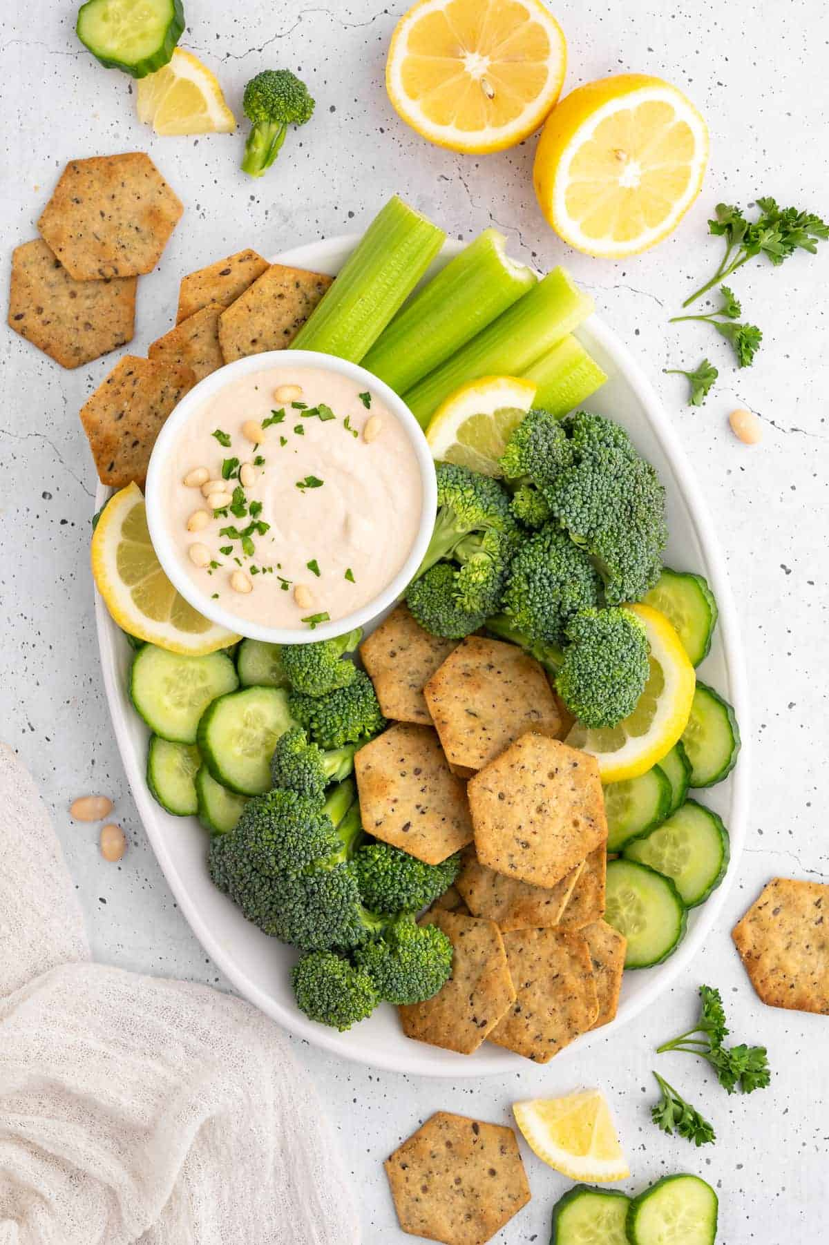 A plate of vegetables and crackers with white bean hummus.
