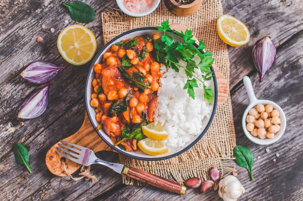 Vegan chickpea Stew Served on a dish with ingredients around.