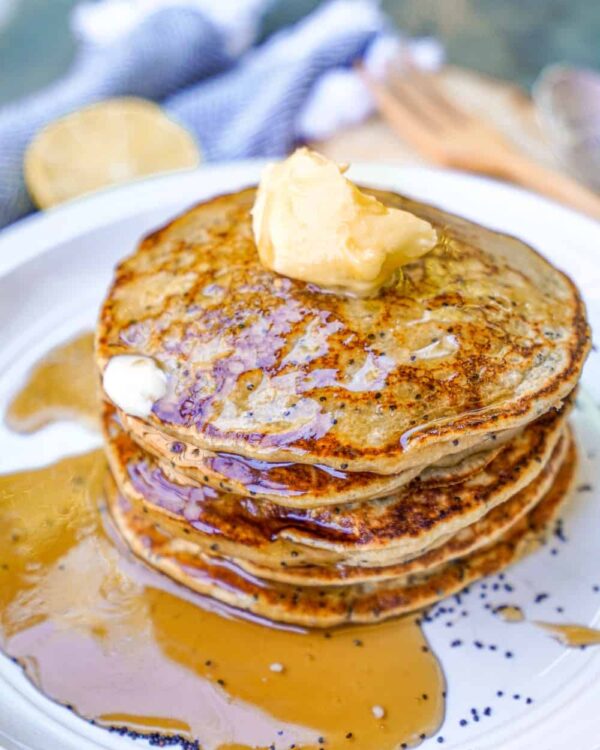 Vegan Lemon Poppyseed Pancakes Stacked with Syrup and Butter